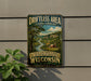 A vintage-style sign for the "Driftless Area Cultural Landscape" in Wisconsin, featuring a scenic landscape with a river, trees, and a barn.
