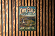 A vintage metal sign for Dry Falls State Park in Washington, featuring a waterfall and a scenic landscape.