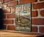 A vintage-style metal sign for Dry Falls State Park in Washington, featuring a scenic landscape with a waterfall and mountains.