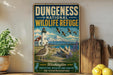 a vintage-style sign for the Dungeness National Wildlife Refuge, depicting a lighthouse, a bird, and a mountain landscape.