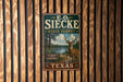 A vintage metal sign for E.O. Siecken State Forest in Texas, featuring a deer and a scenic landscape.