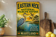 A vintage-style sign for the Eastern Neck National Wildlife Refuge in Maryland, featuring an illustration of a heron and ducks in a natural setting.