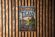 A vintage-style metal sign for the El Camino Real Tejas Heritage Trail in Texas, featuring a scenic illustration of a historic route and a prominent landmark.