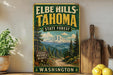 A vintage-style sign for Elbe Hills- Tahoma State Forest in Washington, featuring a scenic mountain landscape and a trail.