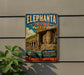 a vintage-style metal sign with the text "Elephantia Caves India" and a depiction of a large stone statue of a deity, likely an elephant, in a cave setting.