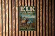 A vintage-style metal sign for the Elk State Forest in Pennsylvania, featuring an illustration of a deer with antlers and a scenic landscape.