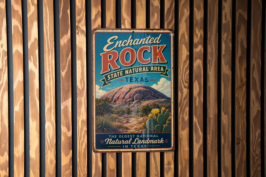 A vintage-style metal sign for the Enchanted Rock State Natural Area in Texas, featuring a desert landscape with a large rock formation and cacti.