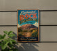 A vintage-style sign for the Enchanted Rock State Natural Area in Texas, featuring a desert landscape with a large rock formation and cacti.