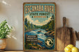 A vintage-style metal sign for Escanaba River State Forest in Michigan, featuring a scenic illustration of a river surrounded by pine trees and mountains.