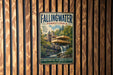 A vintage-style metal sign for Fallingwater, Pennsylvania, featuring a waterfall and a building, is displayed on a wooden wall.