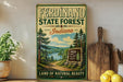 A vintage-style sign for the Ferdinand State Forest in Indiana, featuring a scenic landscape with pine trees, a lake, and mountains.