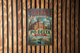 A vintage metal sign for the city of Ferra, Italy, featuring a colorful illustration of the cityscape and text that reads "City of the Renaissance and Po Delta Italy".
