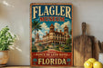 A vintage-style sign for the Flagler Museum in Florida, featuring an illustration of the historic Ponce de Leon Hotel.