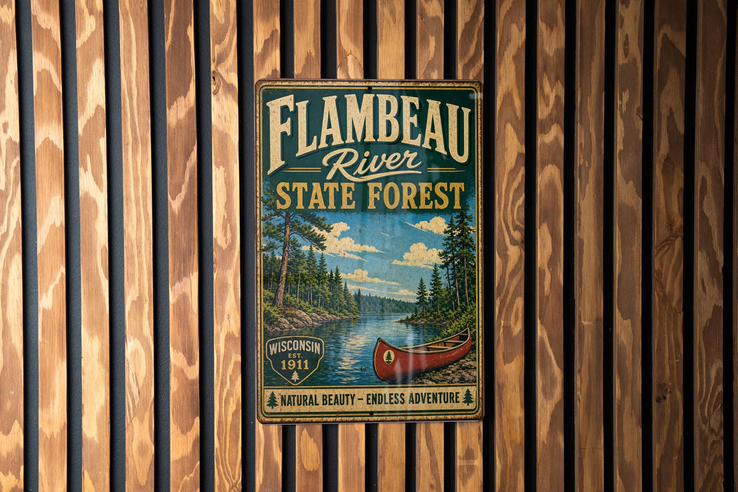 A vintage-style metal sign for the Flambéau River State Forest in Wisconsin, featuring a canoe and a scenic landscape.