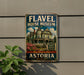 A vintage-style metal sign for the Fl aval House Museum in Astoria, Oregon, featuring an illustration of a Victorian-style house with a porch and flowers.