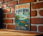 A vintage-style metal sign for the Florida Keys National Wildlife Refuge, featuring an illustration of a turtle swimming in the ocean.