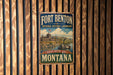A vintage-style metal sign for Fort Benton National Historic Landmark in Montana, featuring a castle and a river.
