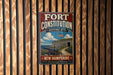 A vintage-style metal sign for the Fort Constitution Historic Site in New Hampshire, featuring an illustration of a fort and a cannon.
