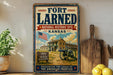 A vintage-style sign for the Fort Larned National Historic Site in Kansas, featuring an illustration of a cannon and a building with an American flag.