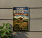 a vintage-style sign for the Fort Necessity National Battlefield in Pennsylvania, Pennsylvania, with a wooden cannon and a stone monument in the foreground.