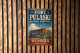 A vintage-style metal sign for Fort Pulaski National Monument in Georgia, featuring an illustration of the fort and its surrounding landscape.