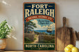 A vintage-style sign for the Fort Raleigh National Historic Site in North Carolina, featuring a ship sailing on the water and a wooden fence in the foreground.
