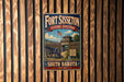 A vintage-style metal sign for FortISSETON Historic State Park in South Dakota, featuring an image of a cannon and a wooden fence.