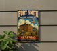 A vintage-style metal sign for the Fort Smith National Historic Site in Arkansas, featuring an illustration of a historic building and a cannon.