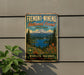 a vintage-style metal sign with a mountain landscape and a lake, mounted on a wall.