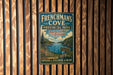 A vintage-style metal sign for "Frenchman's Cove" in New Brunswick, Labrador, featuring a scenic landscape with a river and mountains.