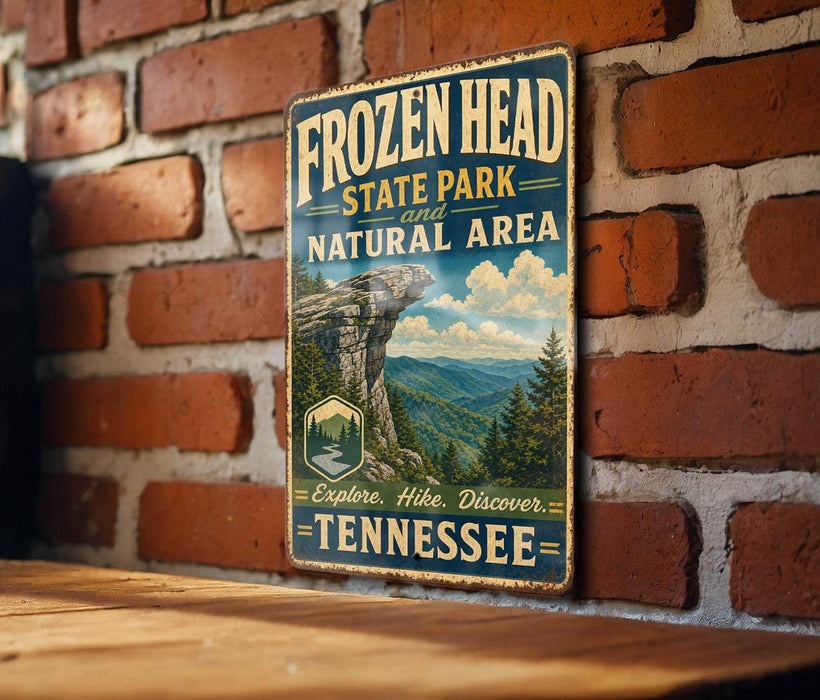 A vintage-style metal sign for Frozen Head State Park and Natural Area in Tennessee, featuring a scenic mountain landscape and encouraging visitors to explore, hike, and discover the park.