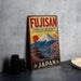 a vintage-style sign for Fujisan, a Japanese company, with a mountain landscape and temple in the background.