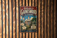 A vintage metal sign welcoming visitors to Gaineswood, Alabama, with a depiction of the town's landmarks and a clock tower.