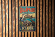 A vintage metal sign with the text "GALAPAGOS ISLANDS ECUADOR" and an illustration of a bird, turtle, and other wildlife, mounted on a wooden wall.