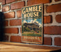 A vintage metal sign for the Gamble House, a historic landmark in Pasadena, California.