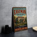 A vintage metal sign for the George Eastman Museum in Rochester, New York, featuring an illustration of the museum building and surrounded by trees.