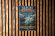 A vintage metal sign with a mountain landscape and text, hanging on a wooden wall.