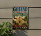 A vintage-style metal sign for Goliad State Park and Historic Site, featuring an illustration of the historic building and a Texas flag.