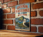 A vintage-style metal sign with the text "GOUGH AND INACCESSIBLE ISLANDS UNITED KINGDOM" and an illustration of a seagull on a grassy island.