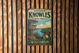 A vintage metal sign for Governor Knowles State Forest in Wisconsin, featuring a scenic landscape with pine trees, a lake, and mountains.