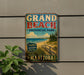 A vintage-style metal sign for Grand Beach Provincial Park in Manitoba, Canada, featuring a beach scene with a wooden walkway leading to the sandy beach.