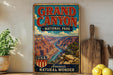A vintage-style sign for the Grand Canyon National Park, featuring a scenic illustration of the canyon and the text "Grand Canyon - NATIONAL PARK - AMERICA'S NATURAL WONDER".