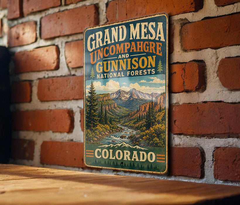 A vintage-style metal sign for Grand Mesa, Colorado, featuring a scenic mountain landscape with a river and pine trees.