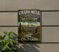 A vintage metal sign for Grand Mesa, Uncompahgre, and Gunnison National Forests in Colorado, featuring a scenic mountain landscape.