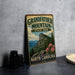 A vintage-style sign for Grandfather Mountain State Park in North Carolina, featuring a mountain landscape with pink flowers.
