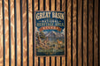 A vintage metal sign for the Great Basin National Heritage Area in Nevada, featuring a mountain landscape and a lone antelope.
