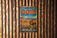 A vintage metal sign with the text "GREAT GOBI Biosphere Reserve" and an illustration of a camel and a gazelle in a desert landscape, mounted on a wooden wall.