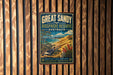 A vintage-style metal sign for the Great Sandy Biosphere Reserve in Australia, featuring a bird and a landscape with a body of water.