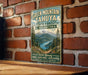 A vintage-style metal sign for Green Mountain- Tahya State Forest in Washington, featuring a scenic mountain landscape with pine trees and a lake.