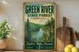 A vintage-style sign for the Green River State Forest in Kentucky, featuring a scenic image of a river surrounded by pine trees and mountains.